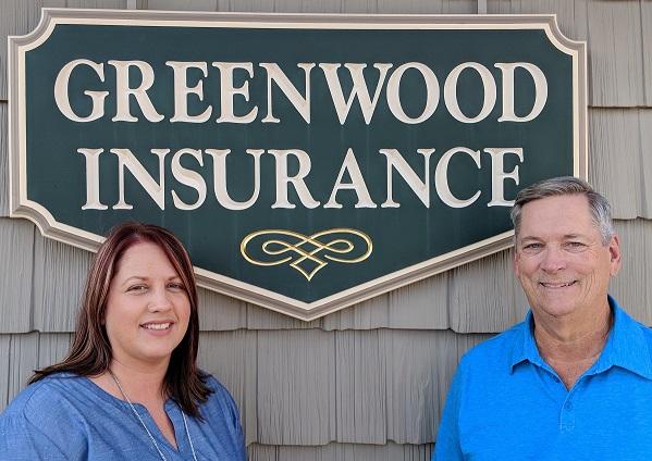 a man and a woman standing in front of a sign